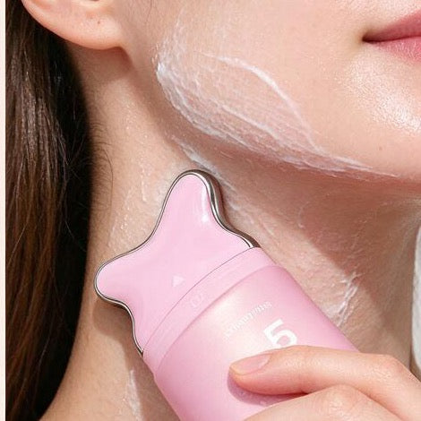 Gliding the Sculpting Serum gua sha applicator along the neck
